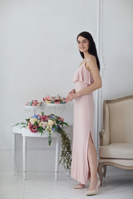 ベビーピンクのロングドレスを着た女性