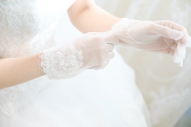 透け感のある白のショートグローブを合わせた花嫁