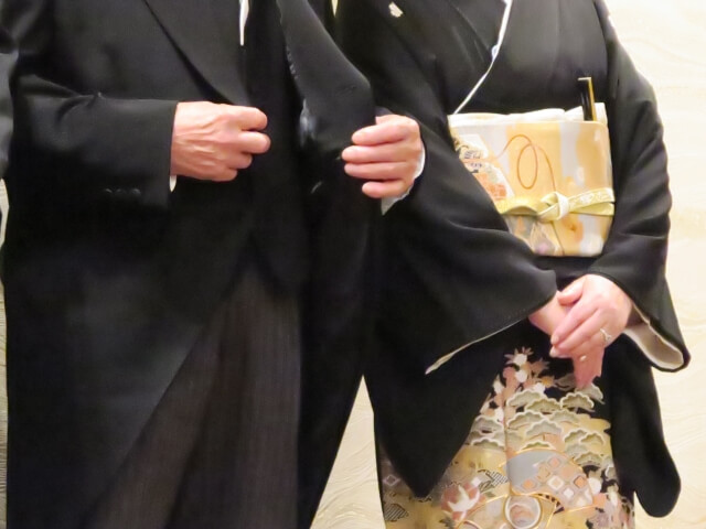 モーニングを着たお父様と袷の黒留袖を着たお母様