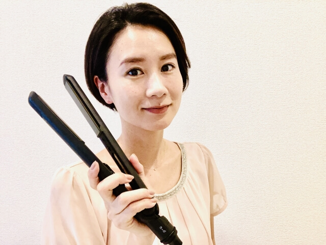 ヘアアイロンを持ったショートヘアの女性