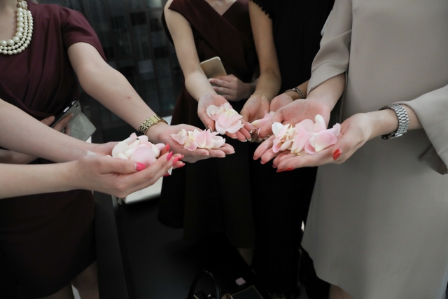 フラワーシャワーの花びらを持つゲストたち