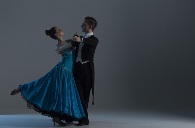 社交ダンスをする二人。燕尾服を着た男性とブルーのドレスを着た女性。