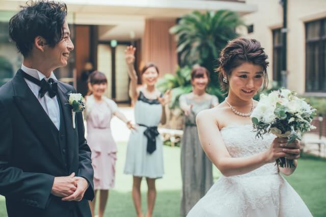 ブーケトスをしようとする花嫁と花婿、ご友人達
